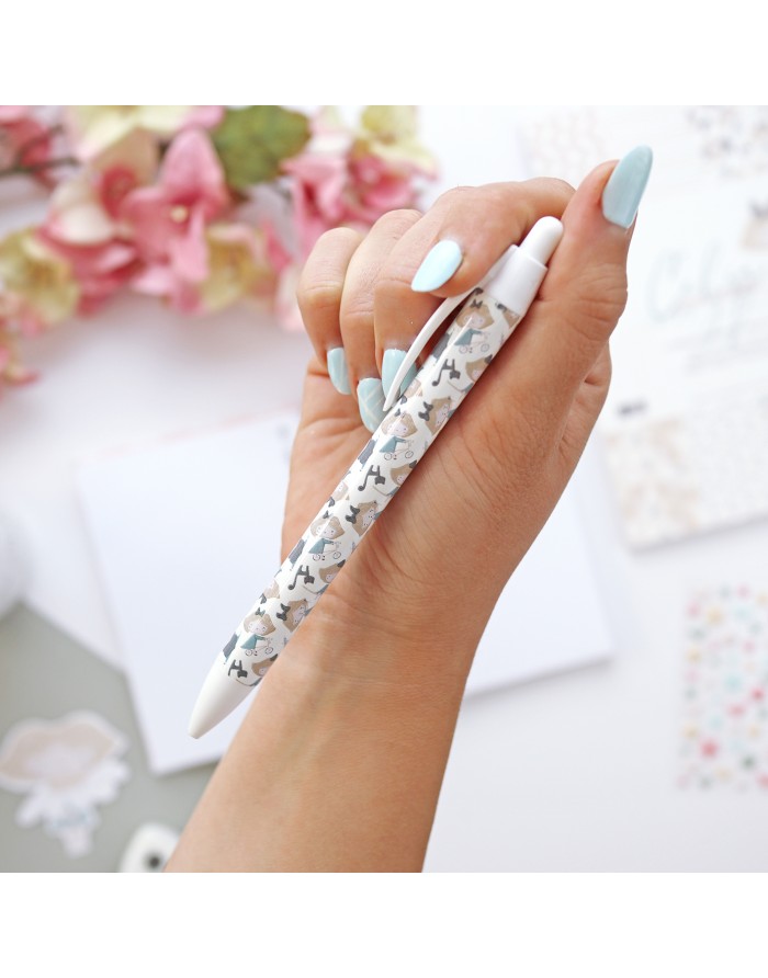 Caneta esferográfica com padrão de cães em tons de cinza e bege na mão