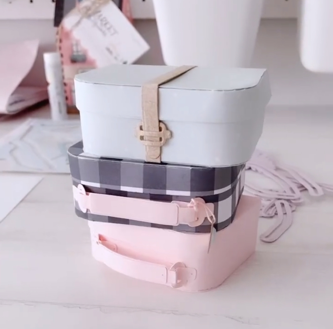 Três caixas retangulares empilhadas com diferentes cores e padrões em fundo branco