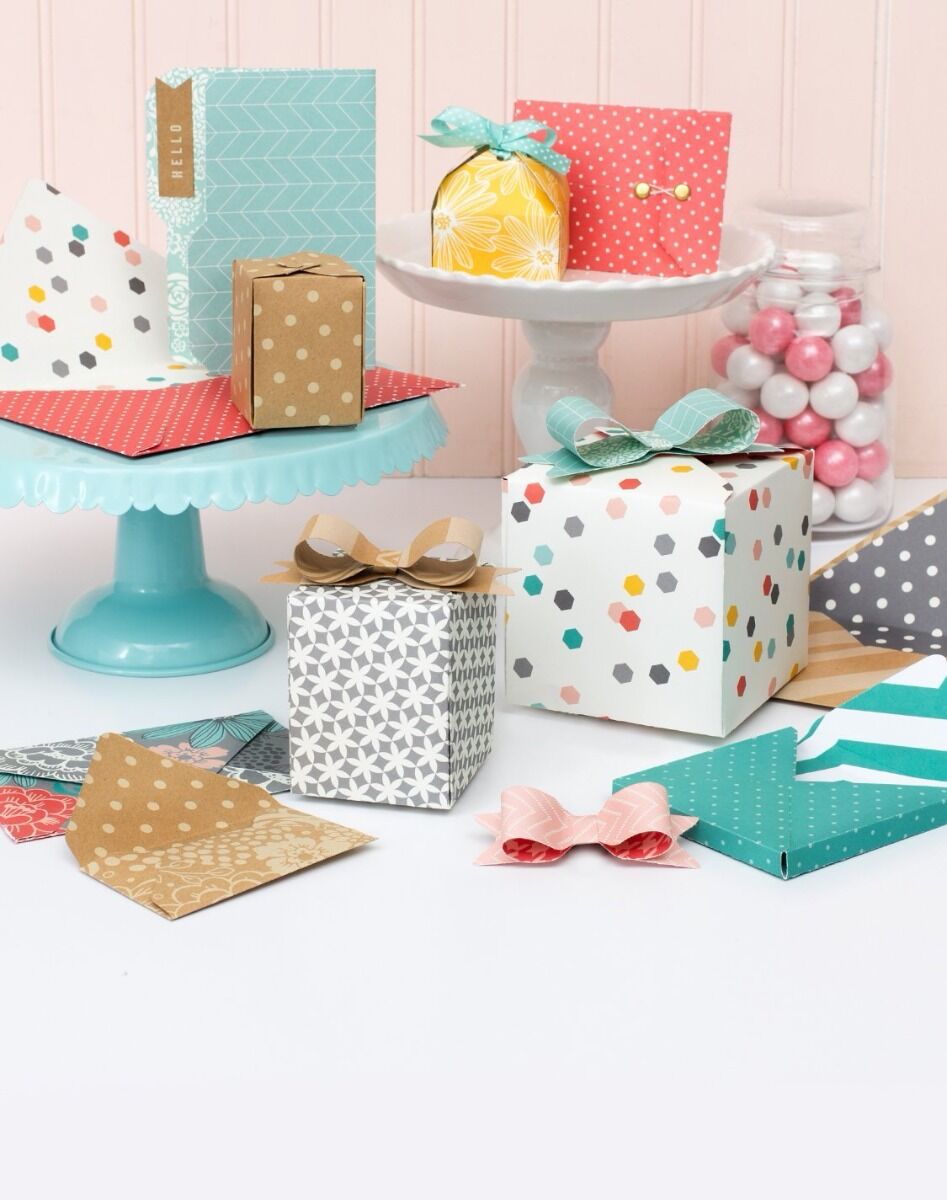 Pequenos presentes coloridos com vários padrões decorativos em suportes de bolo e frasco com gomas.