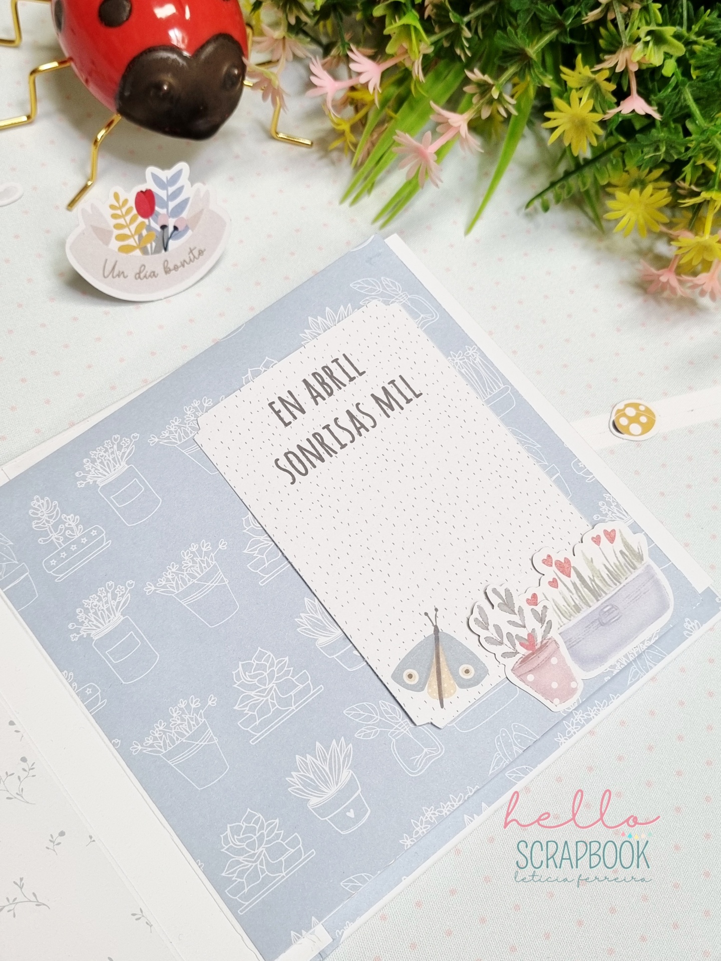 Página decorada de scrapbook com cartão e ilustrações de plantas, inseto e texto em português