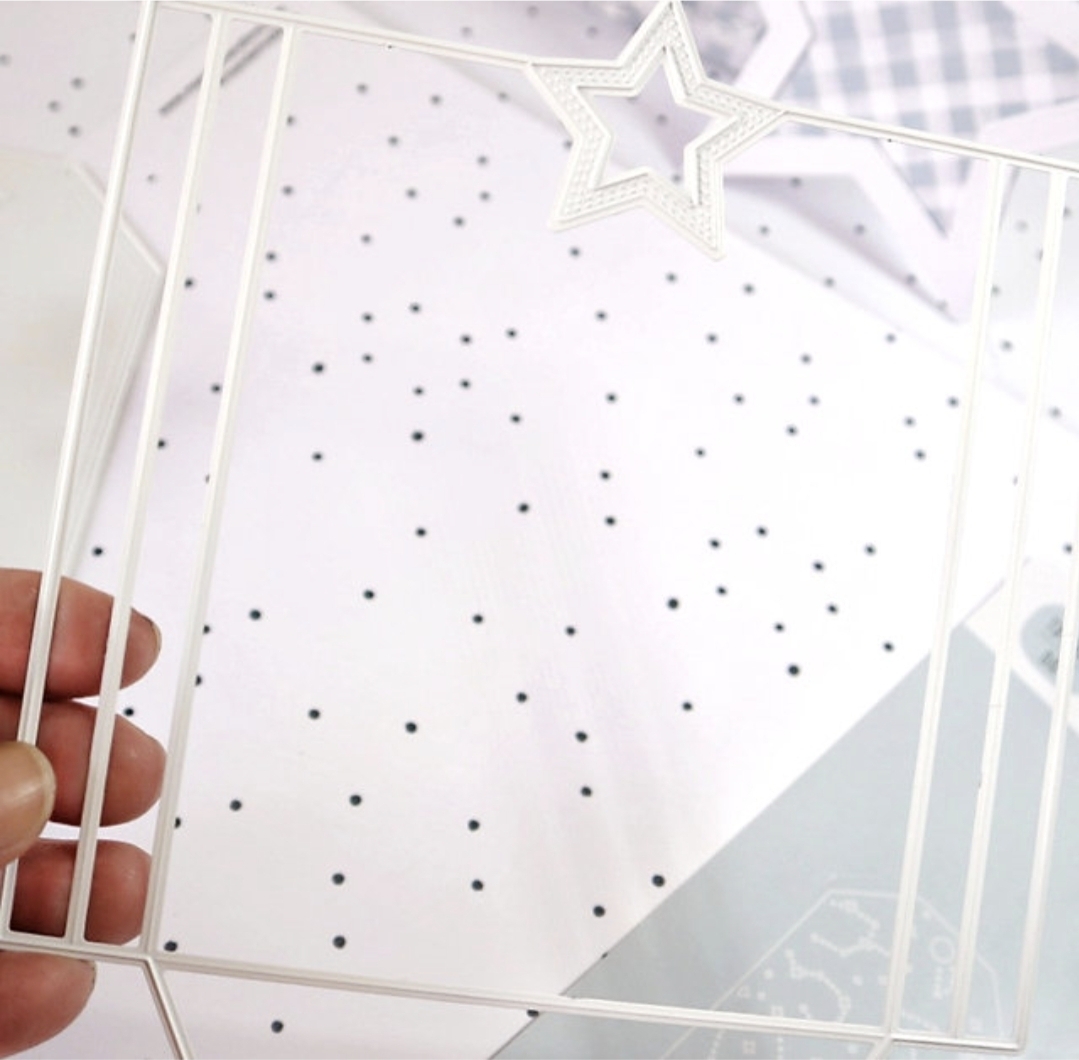 Estrutura metálica branca em forma de estrela segurada por uma mão