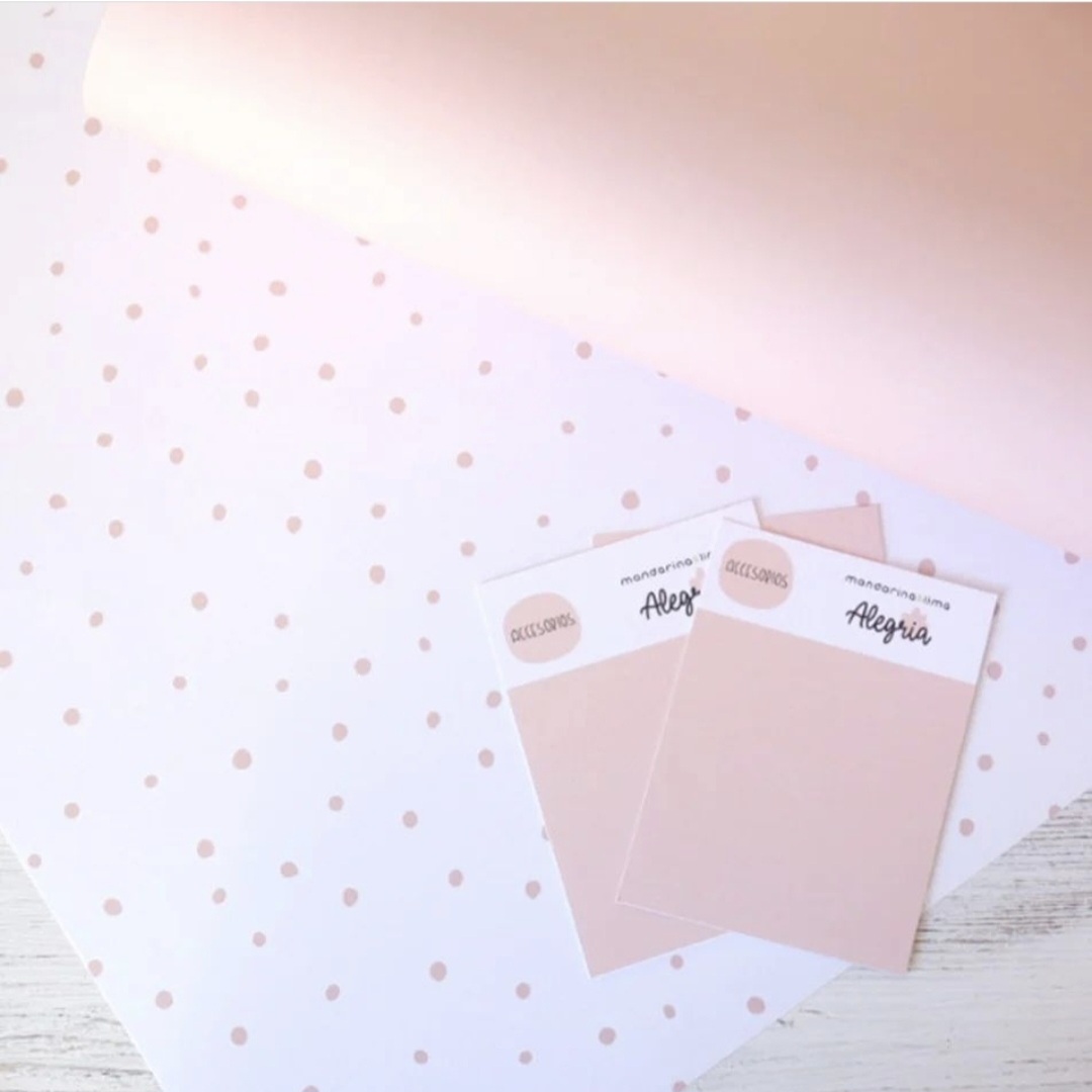 Dois cartões cor de rosa claro com etiquetas e papel branco com bolinhas cor de rosa