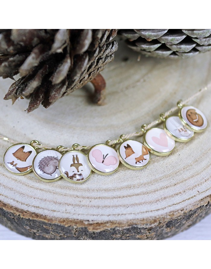 Pulseira dourada com desenhos infantis de animais e coração em medalhões redondos