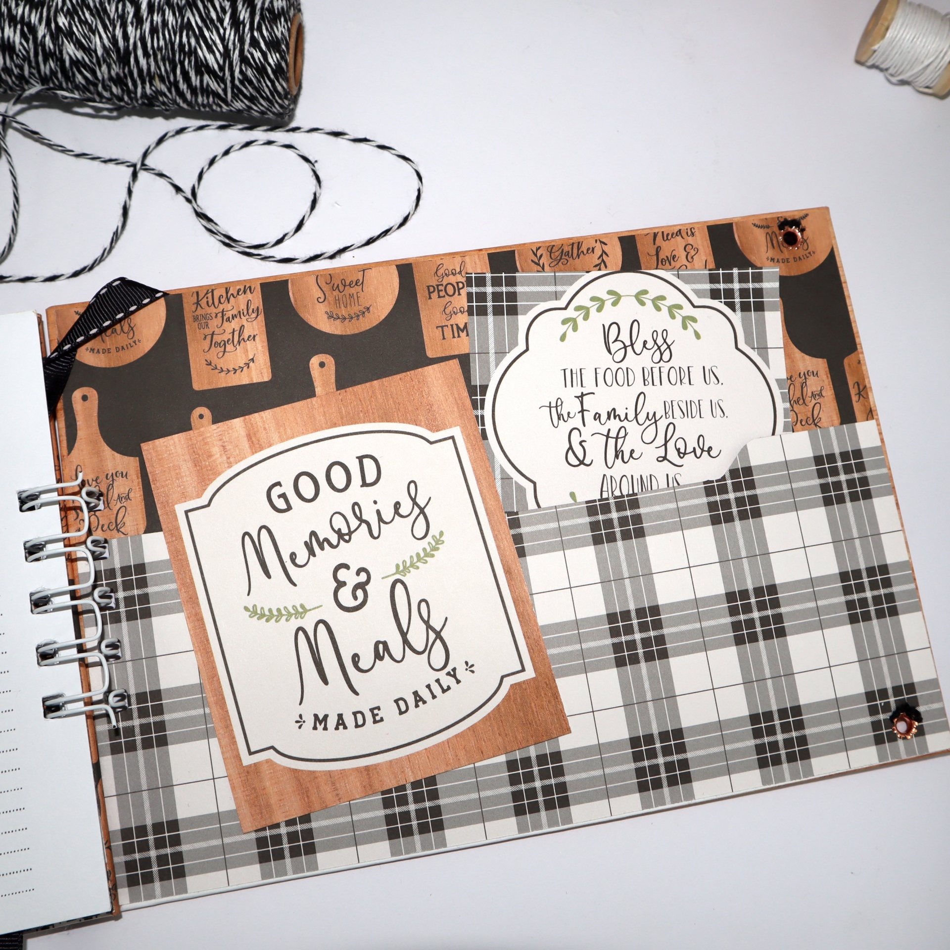 Caderno espiral com capa decorada, padrões xadrez cinza e etiquetas com frases motivacionais