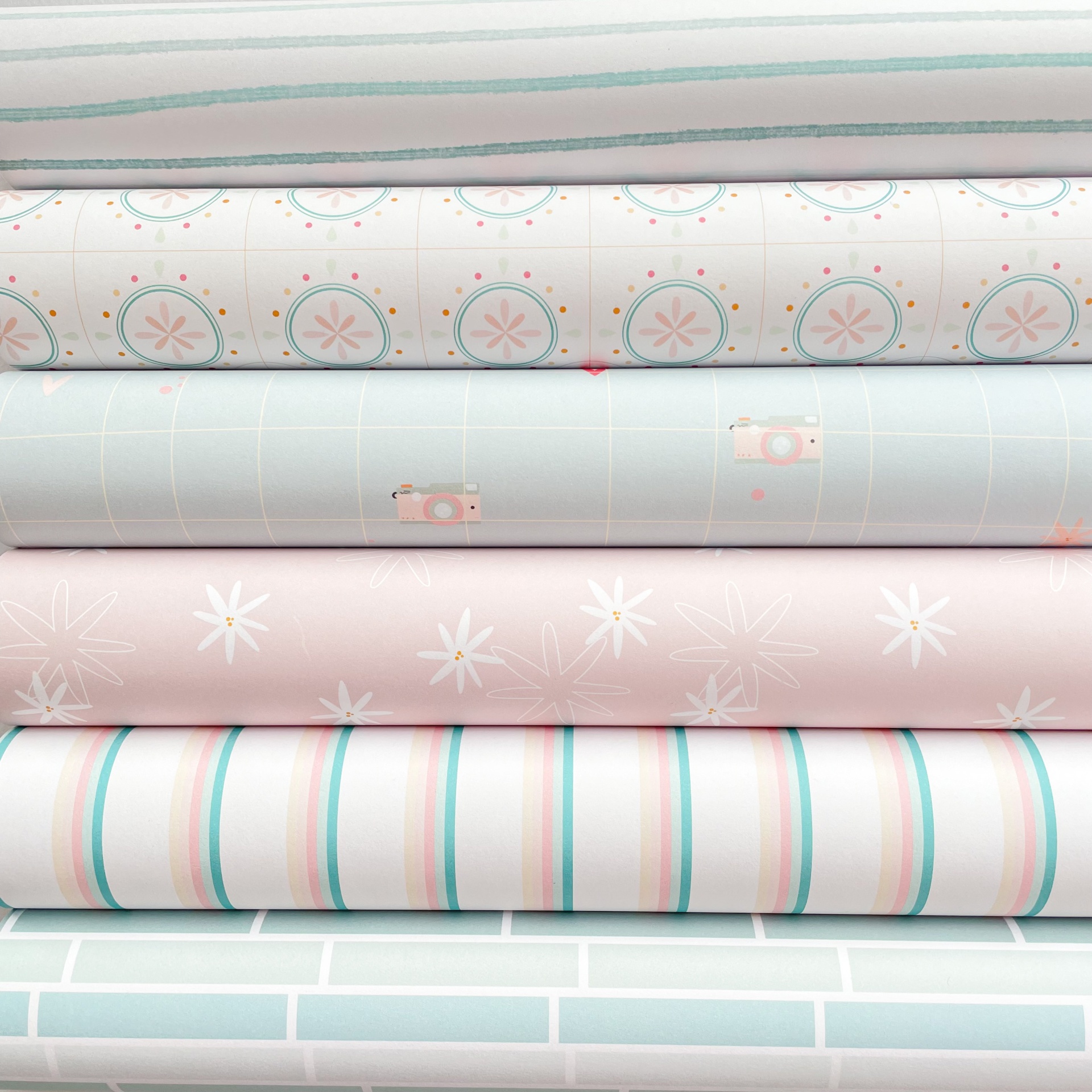 Rolos de papel de parede com vários padrões e cores suaves