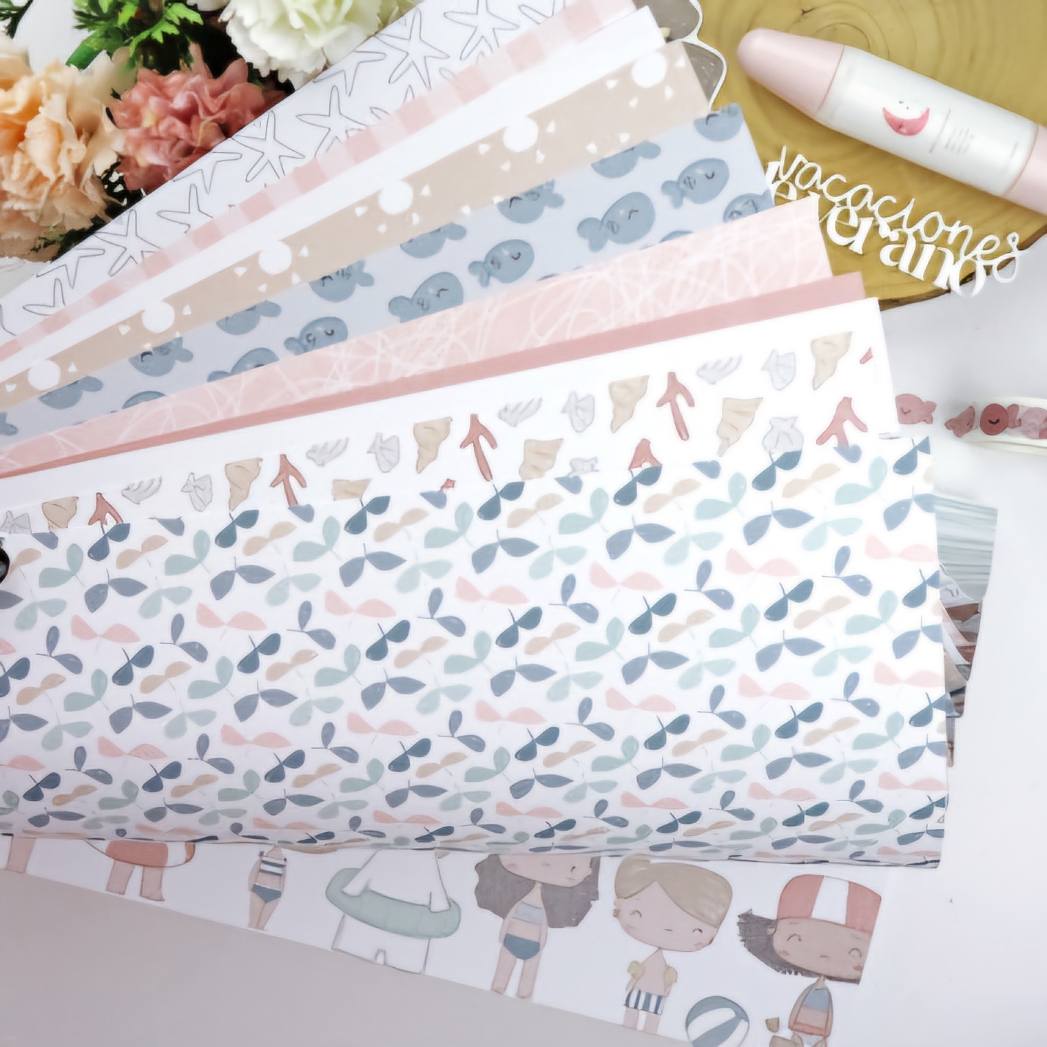 Papel decorativo com padrões em tons pastel e elementos de verão sobre madeira clara