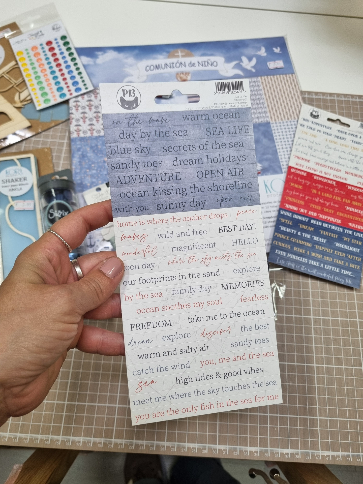 Pacote de papel autocolante decorativo com texto em inglês sobre o mar e mesa de corte com acessórios de papelaria
