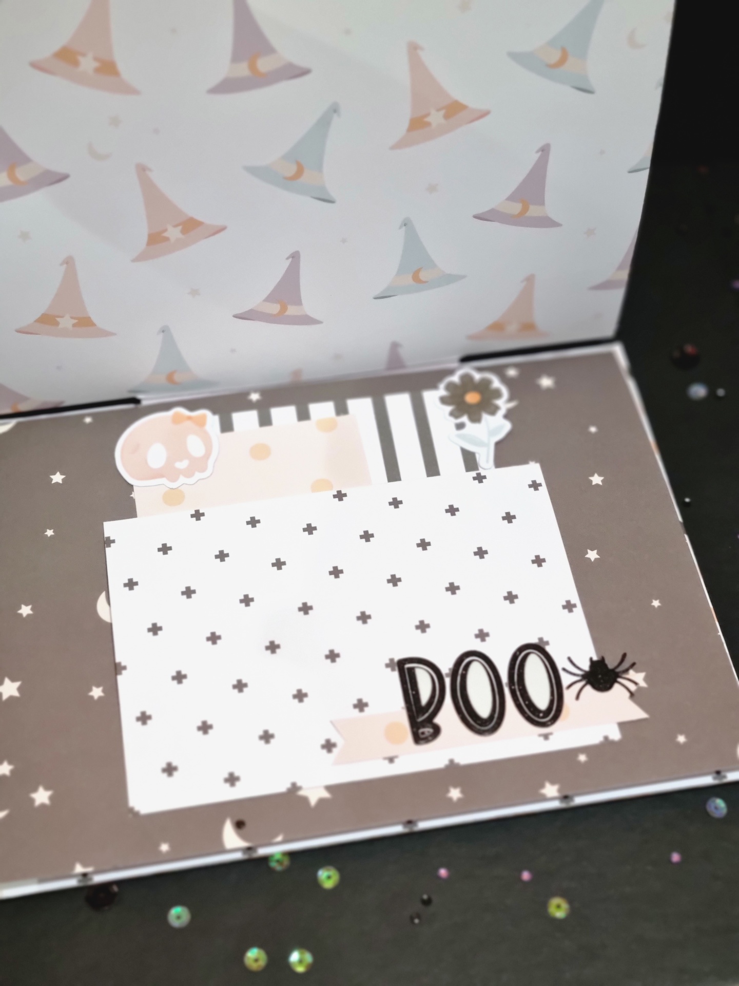 Cartão de papel com tema Halloween, palavra BOO e desenhos decorativos em tons pastel