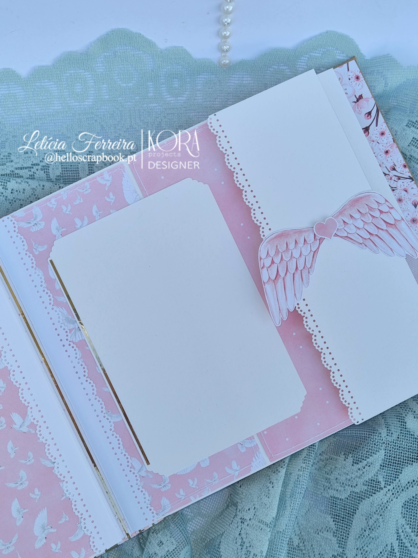 Álbum artesanal com decoração rosa e branca e asas recortadas