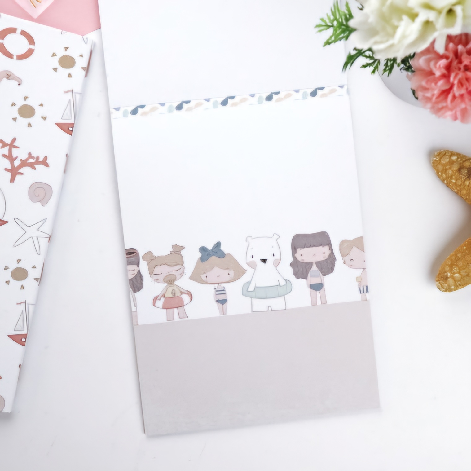 Bloco de notas infantil com ilustrações de bonecos e urso polar em fundo branco e cinza