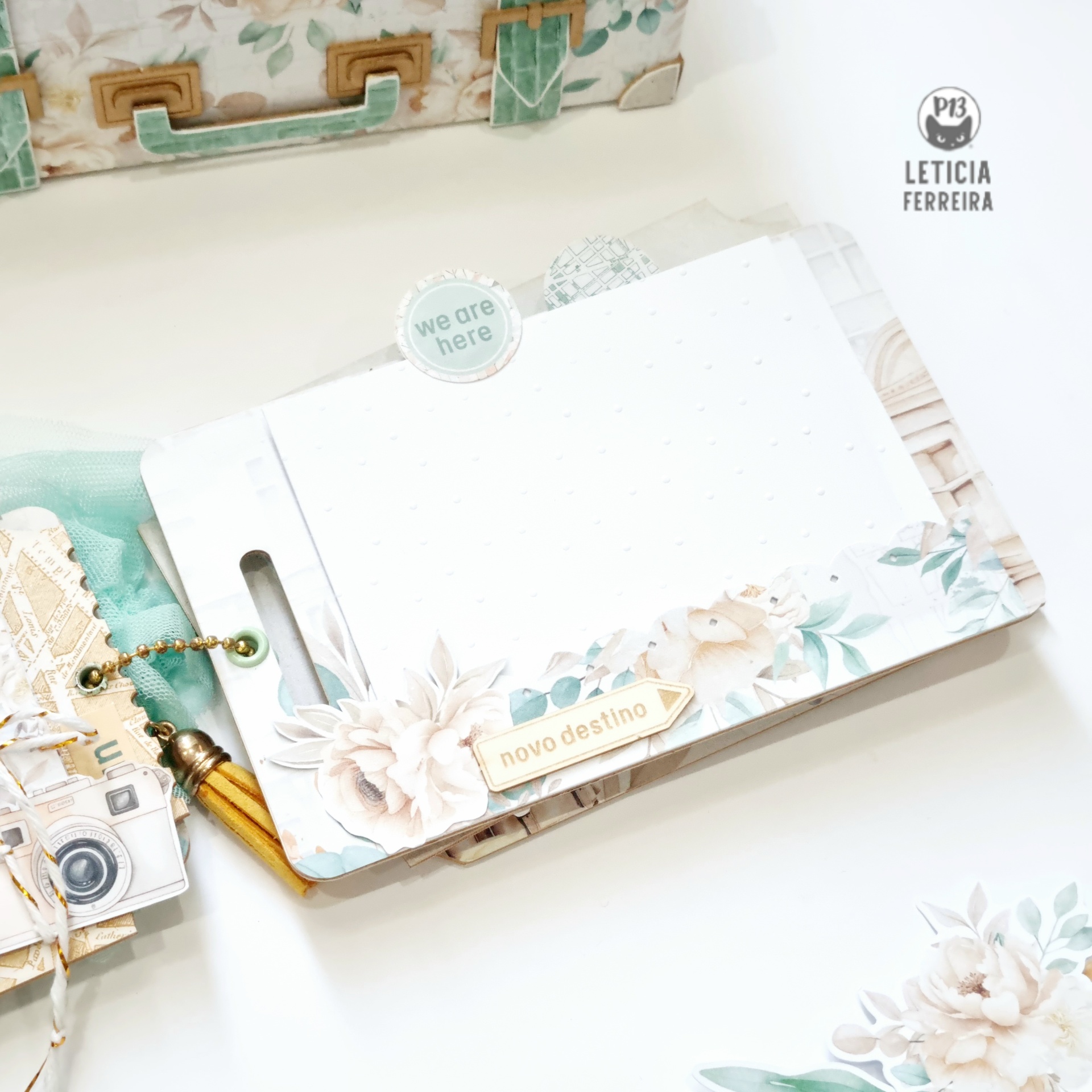 Caderno decorado branco com flores e etiquetas num ambiente claro