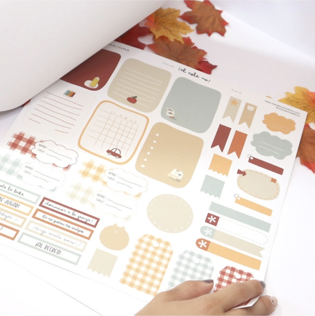 Folha autocolante com etiquetas decorativas coloridas e padrões variados em mesa com folhas de outono