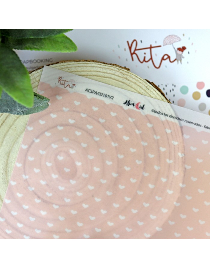 Papel decorativo cor-de-rosa com corações brancos e texto Rita sobre madeira e planta artificial