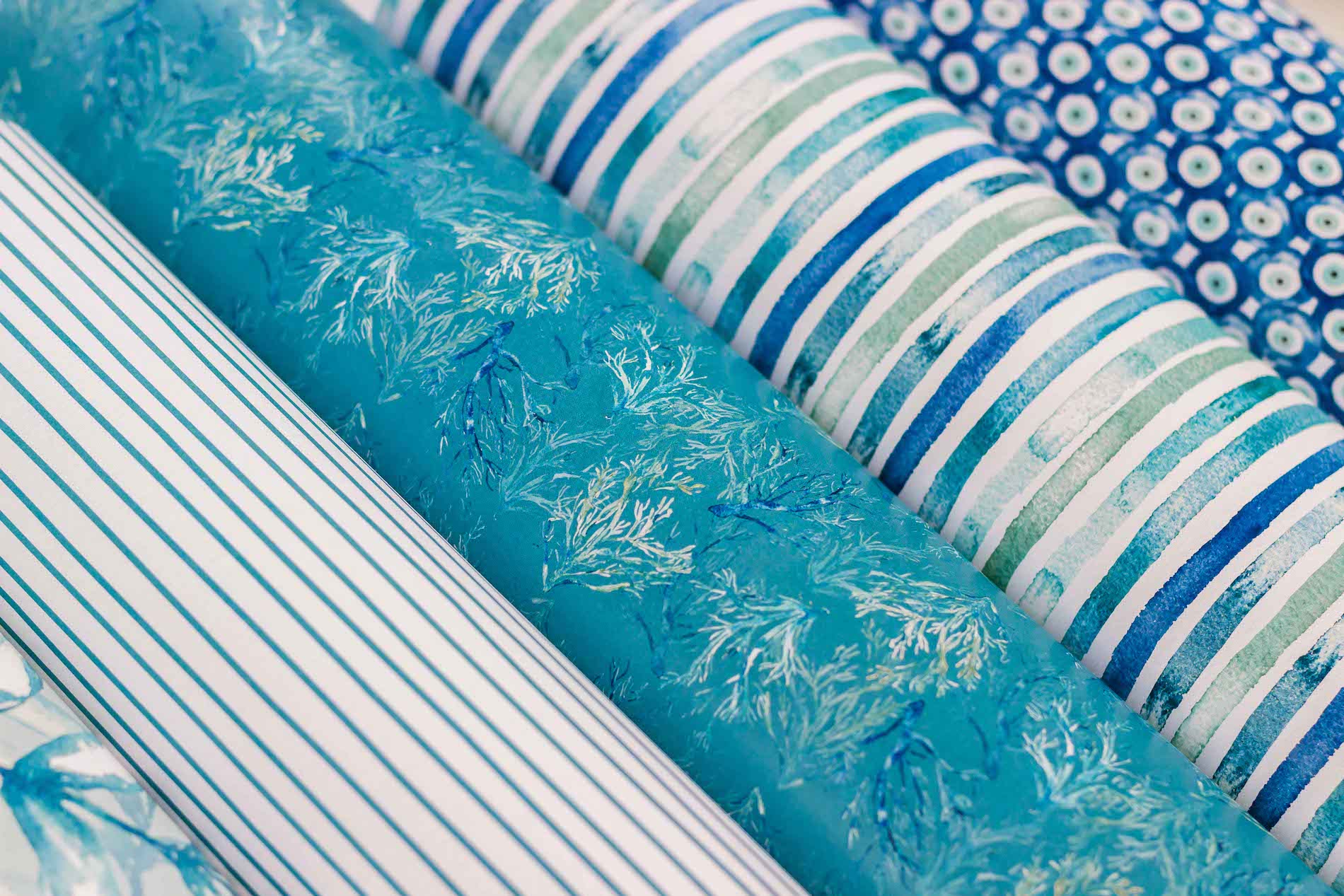 Rolos de tecido azul e branco com vários padrões