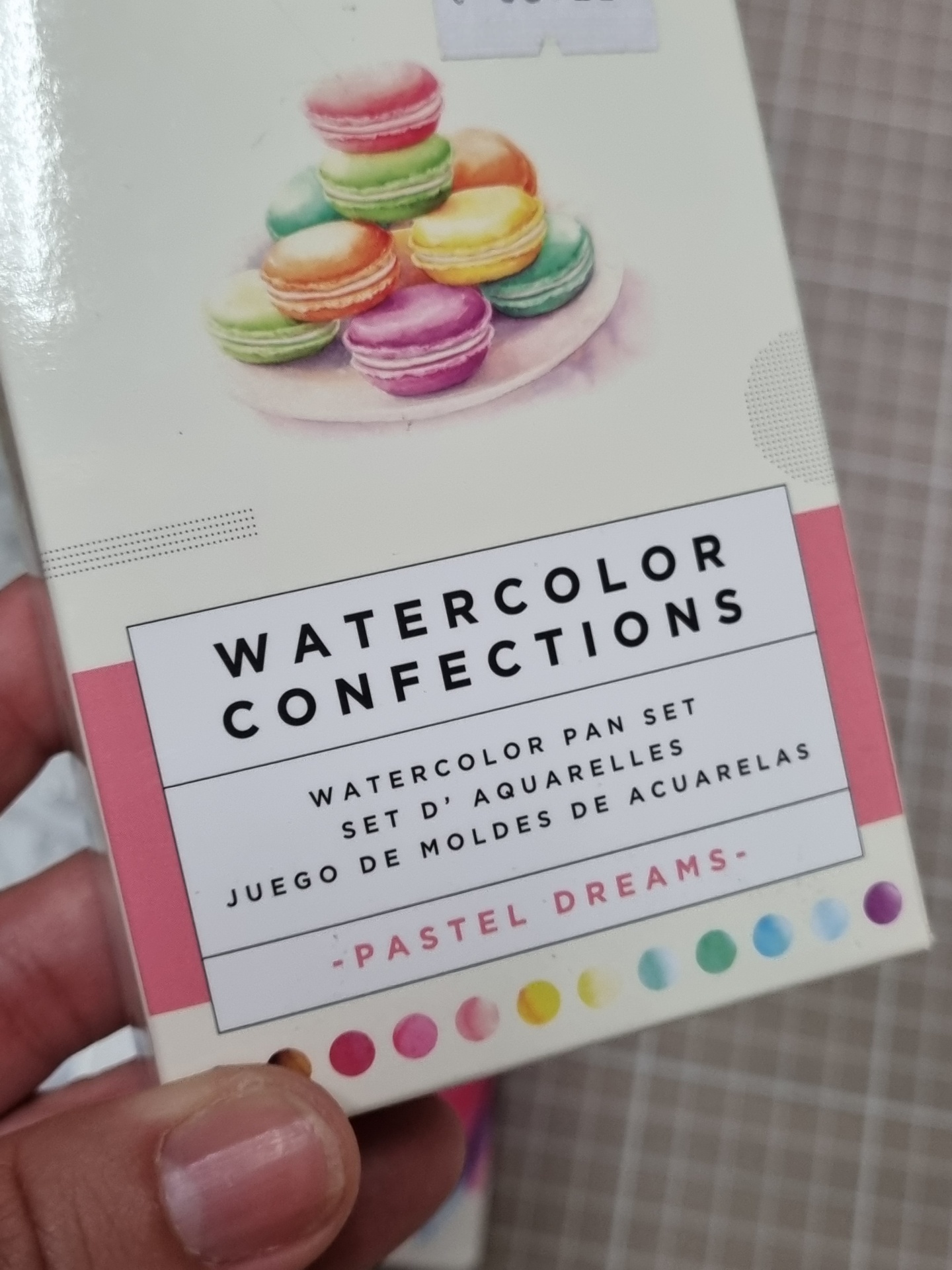Caixa de aguarelas com macarons coloridos e texto