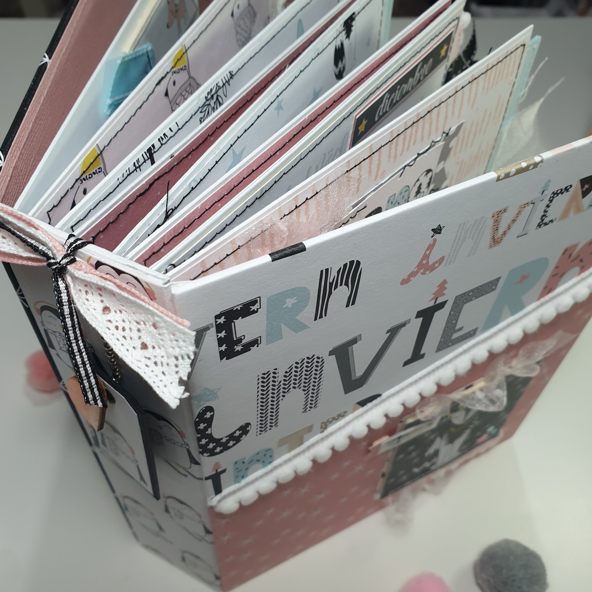 álbum de fotos artesanal com capa colorida e decoração em renda e pompons