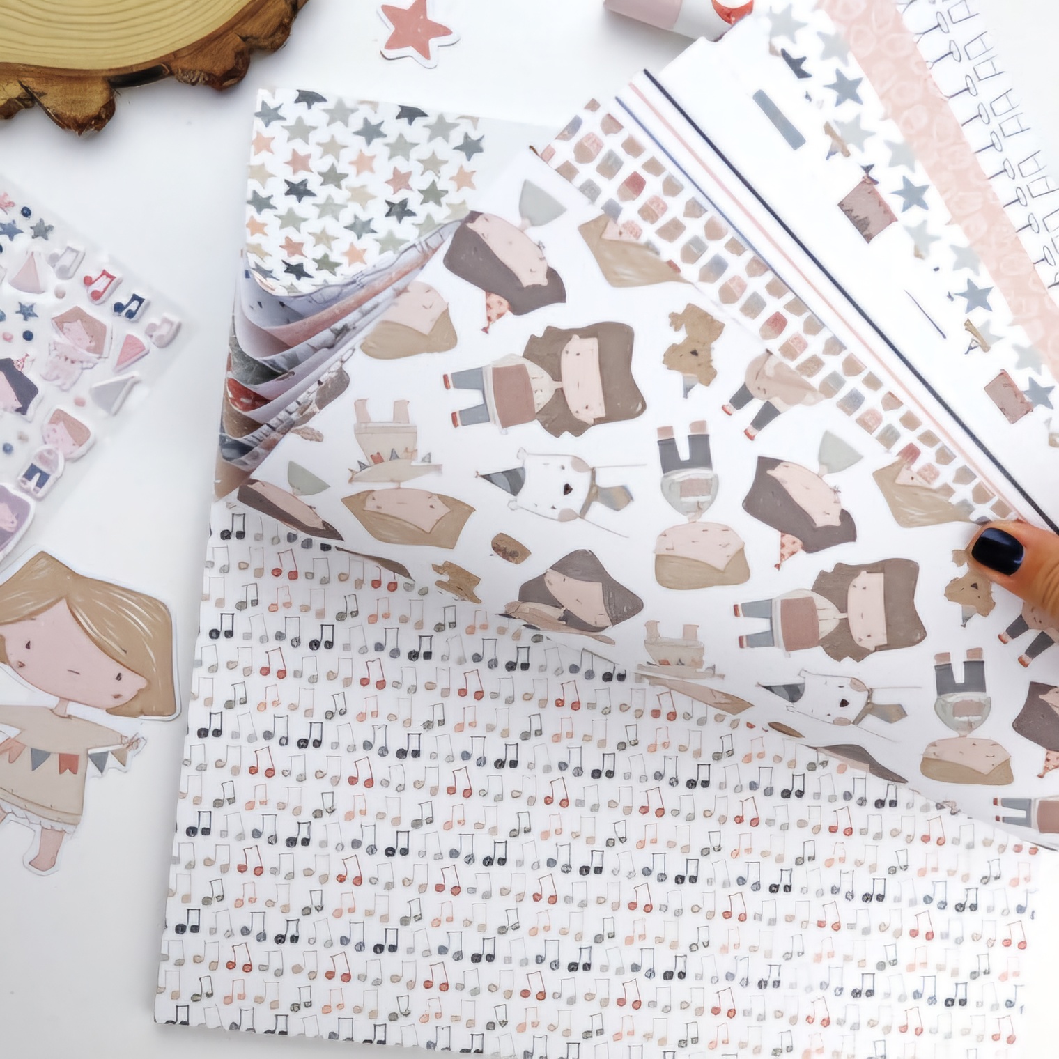 Papéis decorativos coloridos com desenhos de estrelas, raposas e notas musicais.