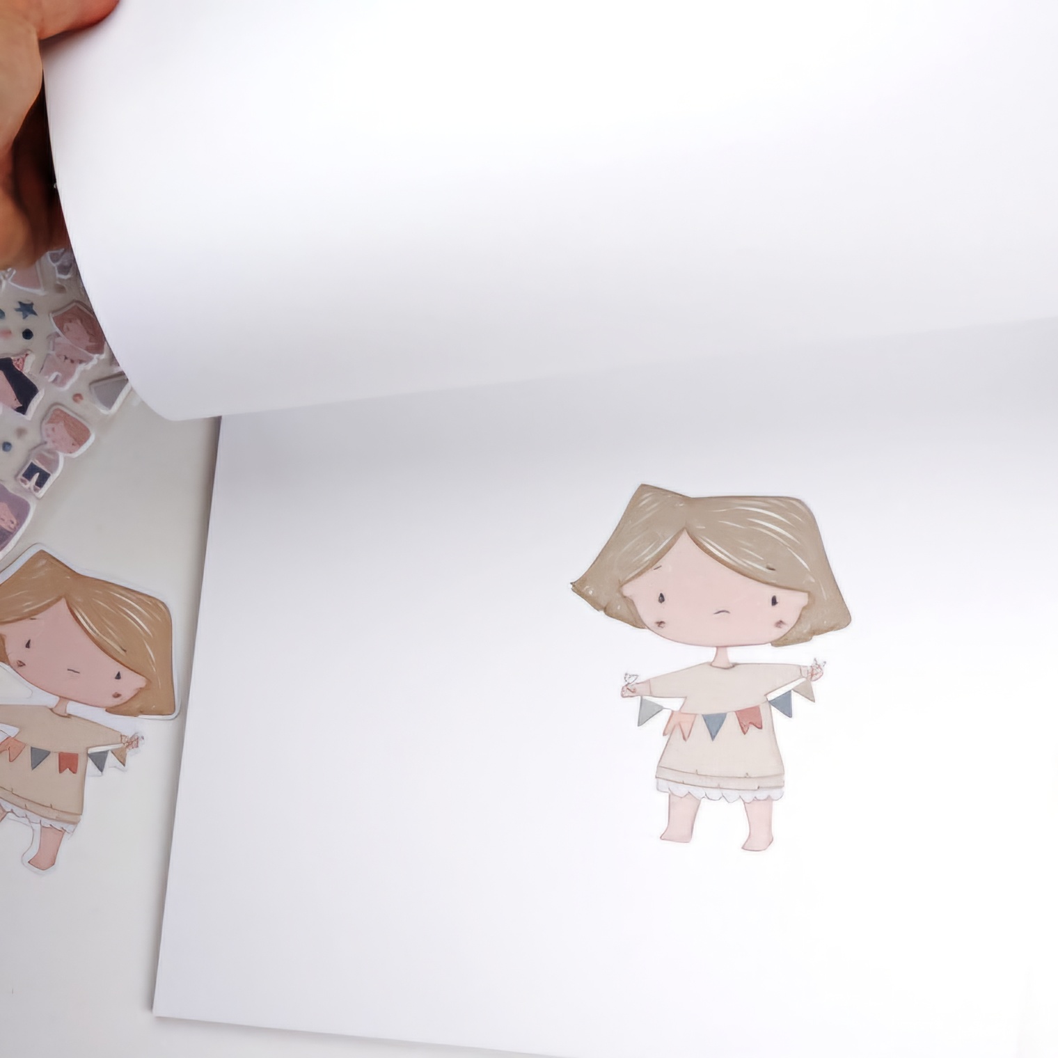 Livro aberto com desenho de menina com vestido bege e bandeirinhas coloridas