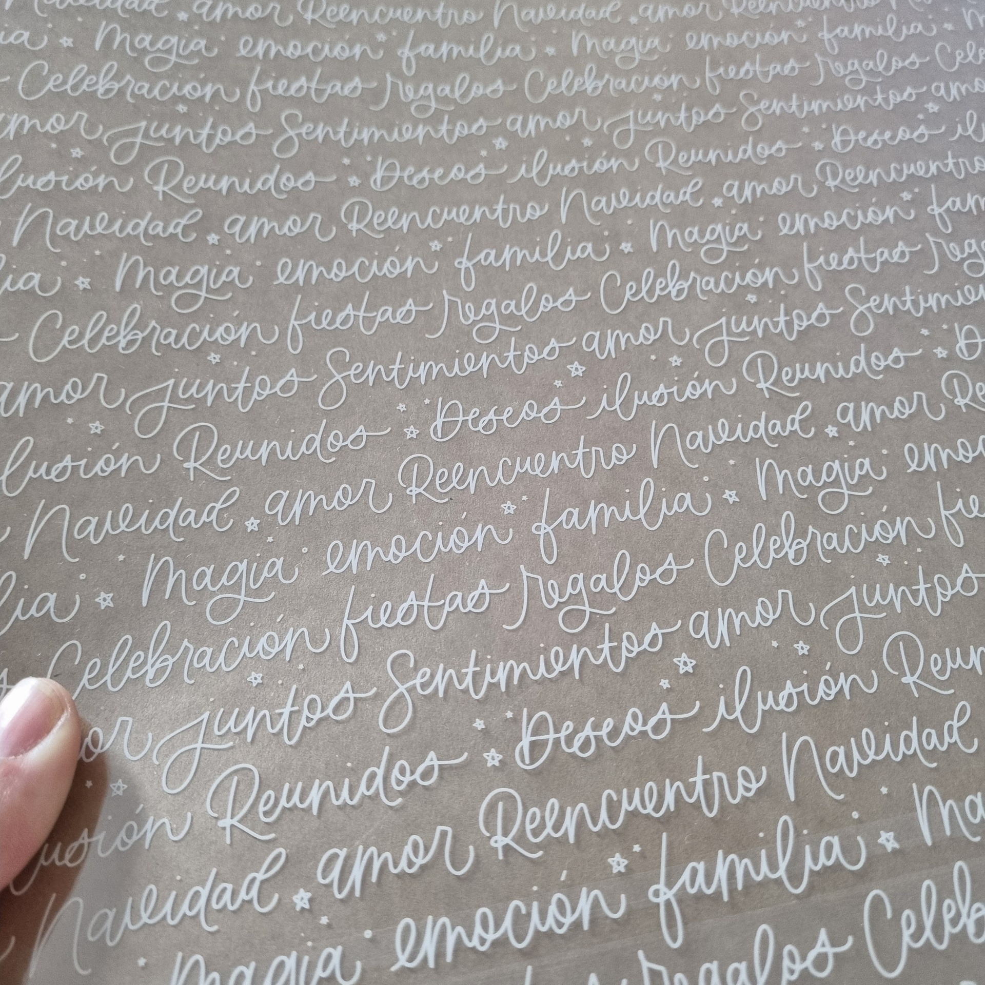 Papel castanho com palavras em branco escritas à mão e pequenas estrelas dispersas