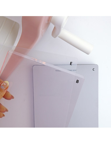 Placas retangulares transparentes e cinzentas com letras E, B, C e dispositivo rosa e branco ao fundo