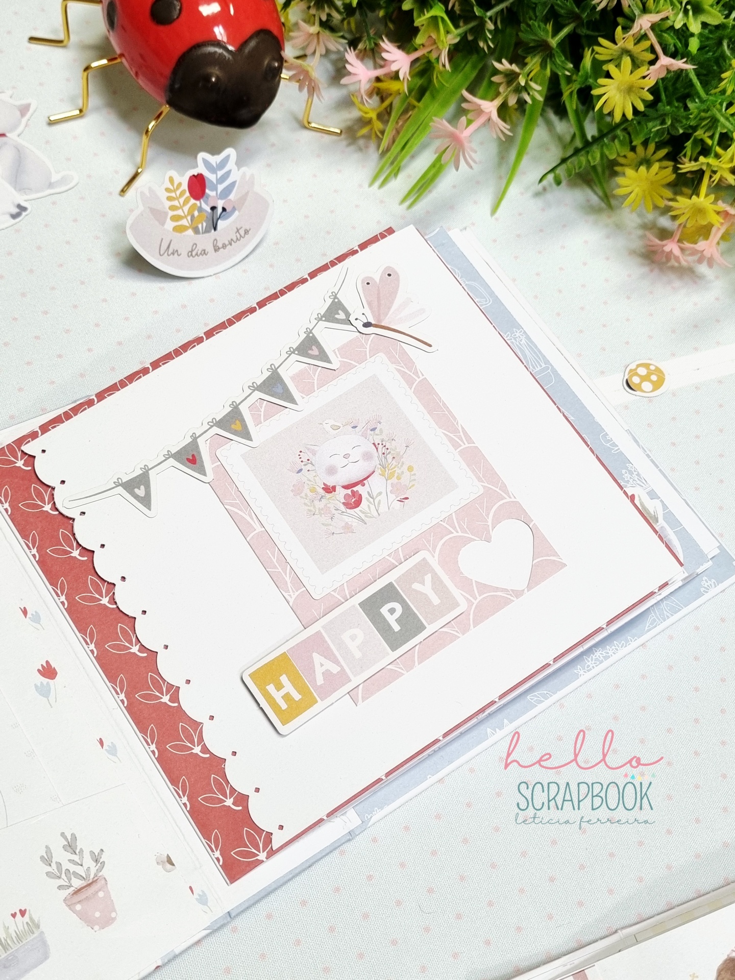 Álbum de scrapbook decorado com tema floral e palavra HAPPY