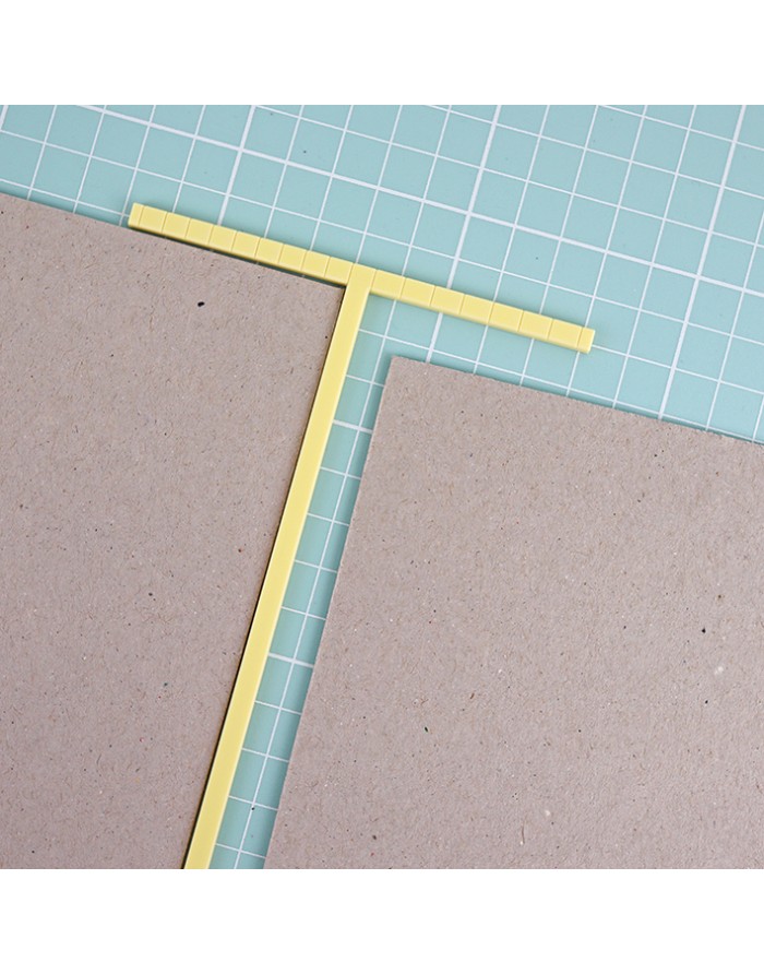 Placas de papelão cinza com réguas amarelas em superfície azul quadriculada