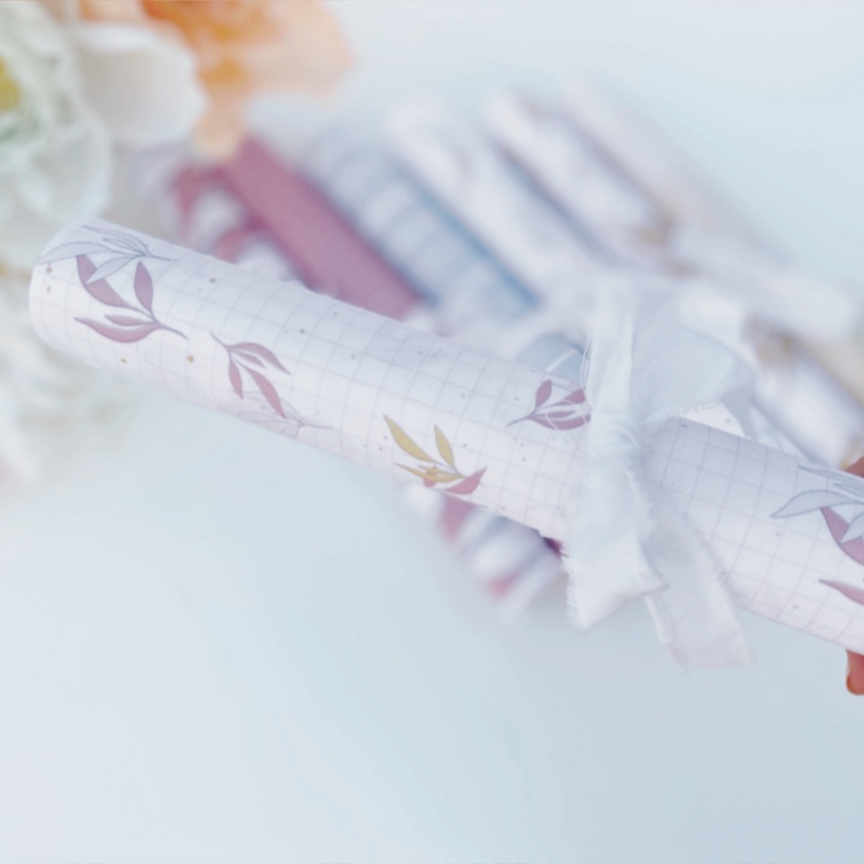 Rolo de papel decorativo com padrão de folhas e fita branca