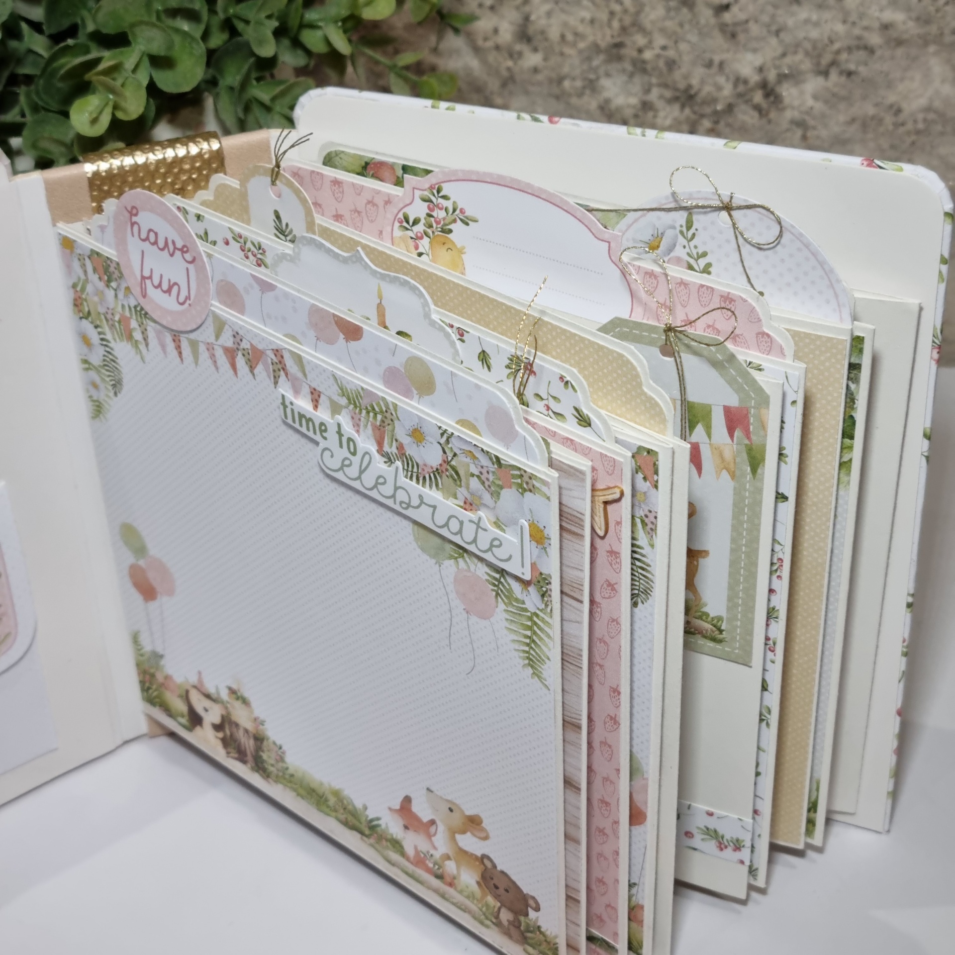Álbum de scrapbook decorado com temas florais e animais sobre superfície branca.