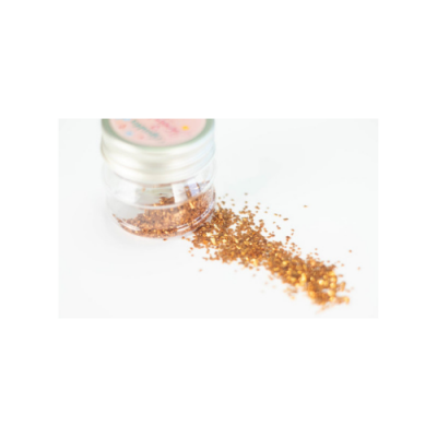 Frasco de glitter dourado com tampa prateada e glitter espalhado