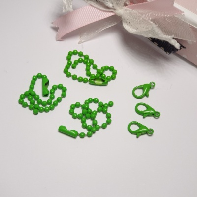 Conjunto de acessórios verdes e fita cor-de-rosa com renda branca ao fundo