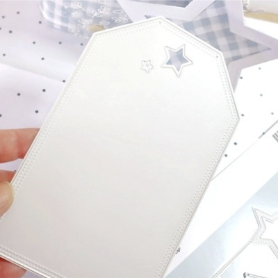 Etiqueta creme com estrela prateada recortada e detalhes de estrelas