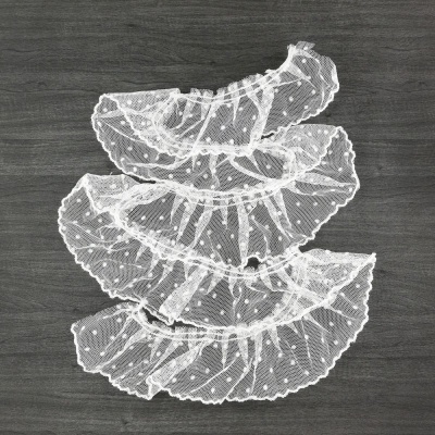 Faixas de tecido branco transparente com pontos em relevo sobre fundo escuro