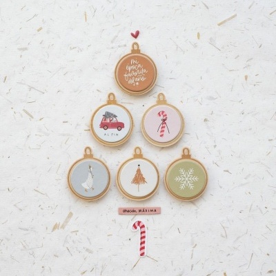 Anéis de bordado com desenhos e cores variados numa disposição de árvore de Natal