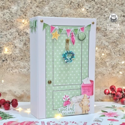 caixa decorativa branca com porta verde com bolinhas e decoração temática de Natal