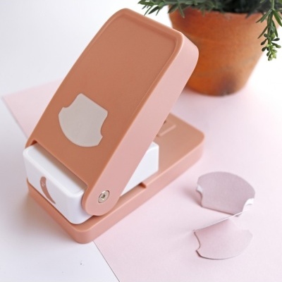 Carimbo de cortiça rosa e branco com formas estampadas e planta em vaso de barro