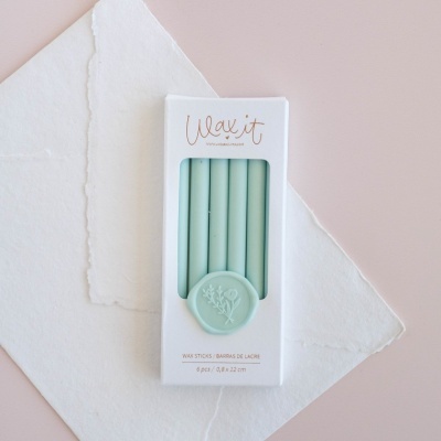 Conjunto de velas verdes num estojo branco com selo de cera verde