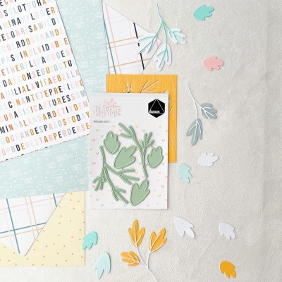 Conjunto de papéis decorativos e recortes de folhas coloridas sobre uma mesa clara