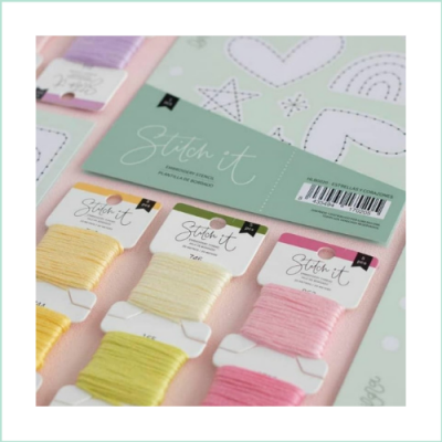 Conjunto de fios para bordado Stitch it em várias cores sobre superfície rosa
