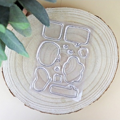 Conjunto de carimbos transparentes em forma de balões de fala sobre placa de madeira redonda