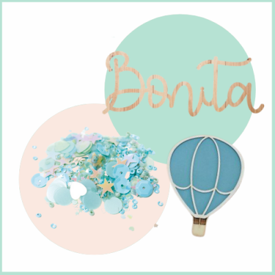 Conjunto decorativo com confetes azuis, balão de ar quente e palavra 'Bonita' em madeira.