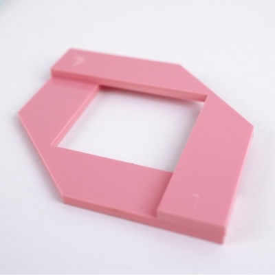 Peça de plástico rosa hexagonal com recorte quadrado