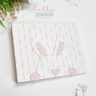 Álbum de scrapbook branco com padrão rosa e recorte de rosto de coelho rosa
