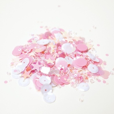 Lantejoulas coloridas rosa, branco e salmão em fundo branco