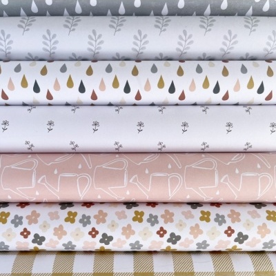 tecidos estampados com folhas, gotas, ramos, regadores, flores e padrão xadrez em cores suaves