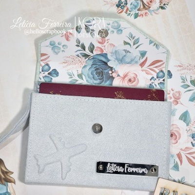 Carteira cinza claro com padrão floral no interior e passaporte vermelho visível