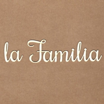 Palavra decorativa em madeira 'la Familia' sobre superfície castanha