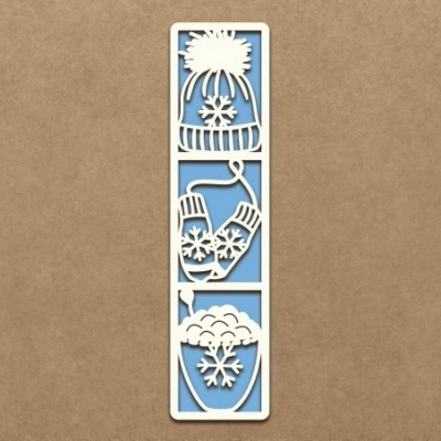 Marcador de livros branco com desenhos de inverno recortados, fundo azul, sobre superfície castanha