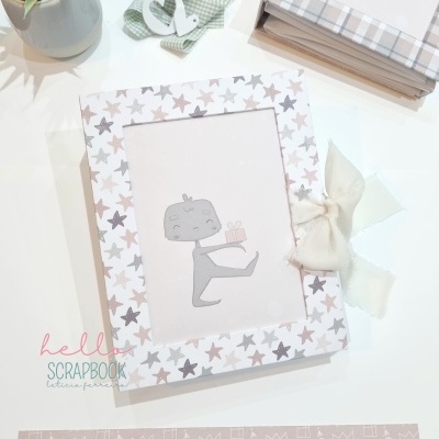 Álbum com capa de estrelas e laço creme em fundo branco