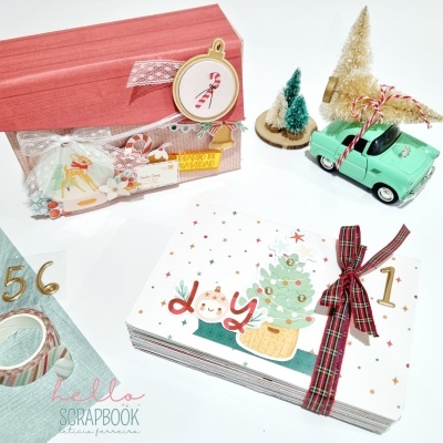 Conjunto de decoração e álbum de fotos natalício colorido com caixa, mini árvores, carro e fita xadrez.