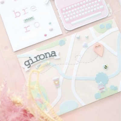 mapa estilizado com palavras girona e relax e objetos decorativos em tons pastéis